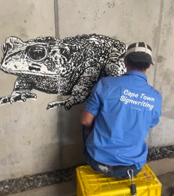 Mural artists hand-painting a wall on site, Cape Town